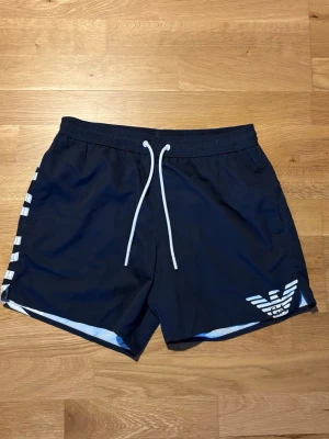 Emporio Armani badbyxor - Tjena! Säljer nu ett par snygga Emporio Armani badbyxor i mörkblått. Badbyxorna är använda men i mycket bra skick, utan defekter. Original bag medföljer.  Storlek: XS Nypris: 849 kr Mitt pris: 229 kr