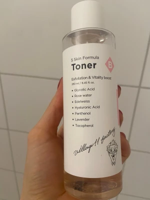 5 Skin Formula Toner från Village 11 - Barely used and opened last week. En genomskinlig toner med exfolierande och uppfriskande effekt från Village 11 Factory. Innehåller glykolsyra, rosenvatten, edelweiss, hyaluronsyra, panthenol, lavendel och tokoferol. Kommer i en rund plastflaska med vit etikett och skruvkork.