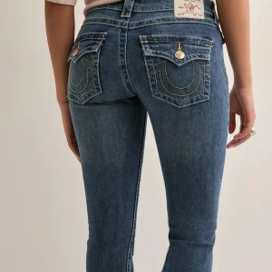 Blå bootcut jeans från True Religion - Super fina jeans från true religion! Använda därav slitningarna längst ned men utöver det är de i bra skick!💗