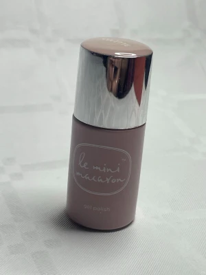 Le Mini Macaron gelnagellack nude - Snyggt gelnagellack från Le Mini Macaron i en mjuk nude-rosa nyans. Flaskans design är stilren med matt finish och ett blankt silverlock. Perfekt för dig som gillar naturliga och eleganta naglar. Lätt att applicera och ger en glansig finish.