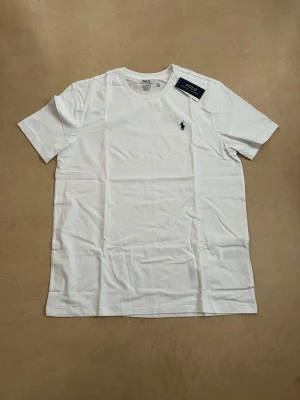 Ralph lauren T-shirt vit storlek large  - Ny Ralph Lauren t-shirt med klassisk passform. Perfekt basplagg till sommaren.  Oanvänd Väldigt populär modell Enkel att matcha  Skickas snabbt 📦 Rabatt vid köp av flera.