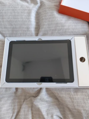 Svart surfplatta i originalkartong - Säljer en svart surfplatta med stor skärm, levereras i originalkartong. Plattan har en modern design med tunna kanter och är perfekt för streaming, surf och appar. Materialet är plast och glas. Laddare och tillbehör kan finnas i kartongen.