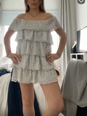 Vit prickig offshoulder klänning Zara - Söt kort offshoulder klänning i vitt med svarta prickar och volanger. Lappen finns men sitter inte fanns på klänningen! Storlek M men passar S oxå!
