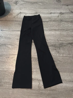 Svarta utsvängda leggings - Svarta leggings med utsvängda ben och hög midja. Mjukt och stretchigt material som sitter skönt på kroppen. Perfekta för en trendig och avslappnad stil.