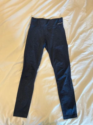 Mörkblå leggings från Newbody - Mörkblå leggings från Newbody med hög midja och diskret leopard mönster. De har tunt mesh tyg i knävecken. Är rätt bra i längd för mig som är 176 cm!💗