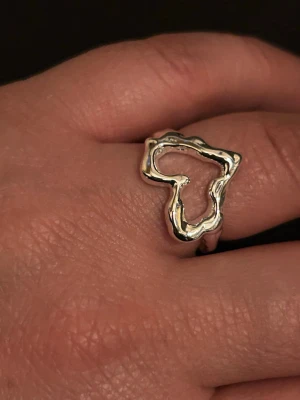 Heart ring  - Stilren ring i silver metall. Ringen har en klassisk och elegant design som passar perfekt för dig som gillar en tidlös look. Perfekt att matcha med andra smycken för en personlig stil.