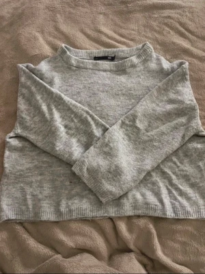 Ljusgrå stickad tröja H&M - Mysig ljusgrå stickad tröja från H&M med rund halsringning och ribbade muddar vid ärmslut och nederkant. Tröjan har en enkel och avslappnad passform, perfekt för lager på lager. Materialet känns mjukt och behagligt mot huden.