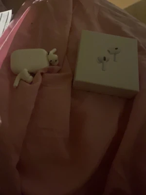 Hörlurar med laddningsetui - Säljer ett par vita hörlurar med trådlöst laddningsetui. Hörlurarna har silikonproppar i olika storlekar, brusreducering och adaptivt ljudläge. Medföljer laddningskabel och originalförpackning. Snygg och kompakt design i plast.