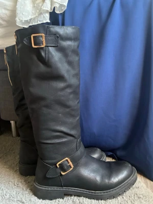 Höga stövlar elle nått - Köpte dom för typ 5 år sen o använde dom typ 5 gånger också, sen dess har dom bara stått i garderoben. Fint skick, lite slitage framtill bara. Kom me prisförslag. Stl 39 men passar säker dig som har 37 också eller 40 efter några gångers användning.