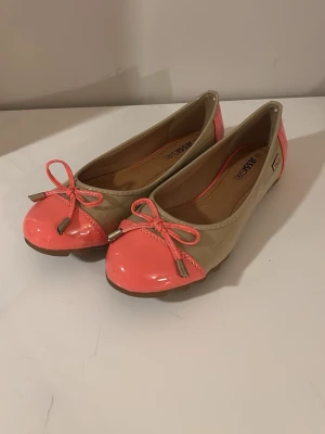 Ballerinaskor, korall  - Säljer helt nya korall färgade ballerinaskor med en glansig yta och snygga rosetter.  Säljer på grund av att de är för små för mig. Jag skulle säga att det är som en 38 även fast det ska vara en 39. Pris kan diskuteras 