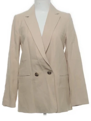 Beige kavaj  - Stilren beige kavaj från H&M i storlek 36. Dubbelknäppt modell med två knappar framtill och två fickor. Klassisk krage och lång ärm. Perfekt för en clean look💕💕⭐️