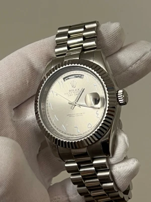Silverfärgad automat klocka med metallarmband - Är EJ intresserad av byten. Stilren klocka med silverfärgat metallarmband och räfflad bezel. Klassisk rund urtavla och robust design som passar dig som vill ha en tidlös accessoar. Perfekt för dig som gillar exklusiva detaljer och kvalitetskänsla. Är EJ intresserad av byten 
