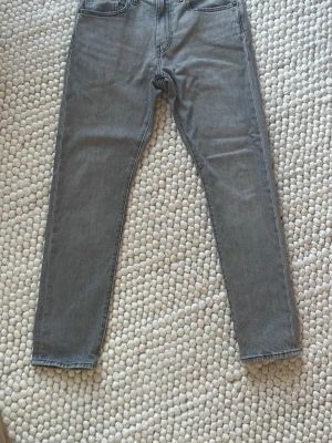 Gråa  jeans från Levi's - Gråa Levis jeans 512 i perfekt skick. Har nästan aldrig kommit till användning. Storlek 30/30. Hör av er vid fler frågor.