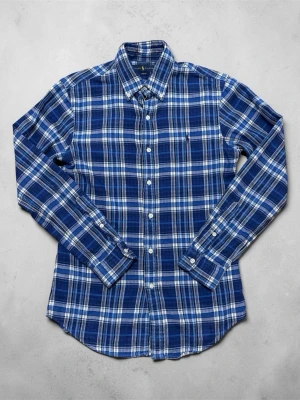 Blårutig skjorta från Ralph Lauren - Snygg blårutig skjorta från Ralph Lauren i slim fit-modell. Skjortan har långa ärmar, klassisk krage och knäppning framtill. Tillverkad i mjuk bomull som känns skön mot huden. Perfekt för dig som gillar en stilren och avslappnad look.