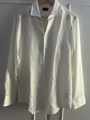 Vit skjorta från Zegna i linne - Klassisk vit skjorta från Zegna i svalt linne. Skjortan har lång ärm, knappar framtill och en stilren krage. Perfekt för en clean och fräsch look. Passar dig som gillar tidlös stil och premiumkänsla.