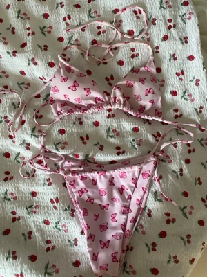 Fjäril bikini  - Rosa bikini med mörkrosa fjärilar på!💞Storlek S!! Överdelen har inlägg i sig, och både under och överdelen går att justera med banden!!