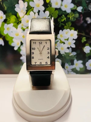 Stilren silverfärgad rektangulär klocka - Stilren klocka med rektangulärt silverfärgat ur och svart läderband. Tydlig vit urtavla med svarta siffror och klassisk design. Perfekt accessoar för dig som gillar enkel och tidlös stil.Nytt batteri, säljes i befintligt skick enligt bilderna! 