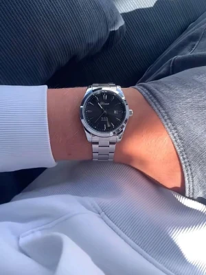 Silverfärgad  klocka med svart urtavla från Doventi  - Stilren klocka från Doventi med svart urtavla och datumvisning. Armbandet är i blankt silverfärgat metall och klockan har klassisk rund form. Perfekt accessoar för dig som gillar en clean och modern look.