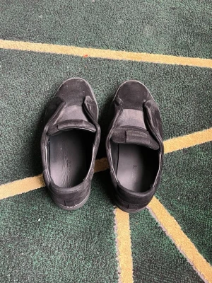 Axel Arigato laceless  - Svarta axel arigato  sneakers  med elastiskt band över vristen. Skorna har en minimalistisk design utan snörning och är tillverkade i textil och syntetmaterial. Perfekta för en clean och avslappnad stil. Jag har bara använt dem i 2 månader 