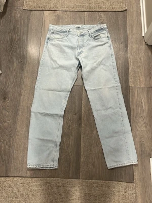 Ljusblå loose fit jeans LOOSE/CHRIS - Säljer ett par ljusblå loose fit jeans med rak passform från LOOSE/CHRIS. Jeansen har klassisk femficksdesign och är tillverkade i denim. Perfekta för en avslappnad och trendig stil.