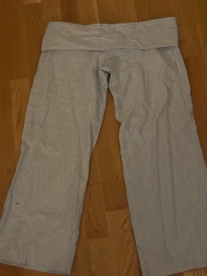 Randiga pyjamasbyxor i bomull - Mysiga pyjamasbyxor med tunna vita och ljusblå ränder. Byxorna har en bred linning och raka ben, perfekta för att chilla hemma. Tillverkade i mjukt bomullstyg som känns skönt mot huden. Om du intreserad jag vill bara förvarana att dom här byxorna är från en liten företag som hetter jennifer.