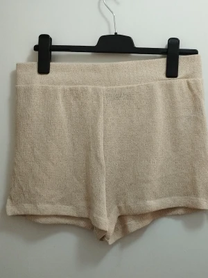 Beige stickade shorts som andas - Svala beige stickade shorts med resor i midjan och avslappnad passform. Perfekta för chill dagar hemma eller när du vill vara extra bekväm. För mått se övriga bilder. Använda en gång. Kolla gärna mina andra annonser <3