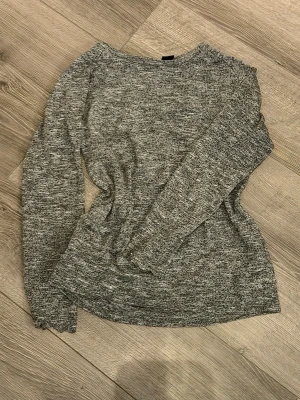 Gråmelerad  tröja Lindex - Gråmelerad stickad tröja från Lindex i storlek XS. Tröjan har rund halsringning, långa ärmar och är gjord i ett mjukt, stretchigt material. Enkel och stilren modell som är lätt att matcha med olika plagg.