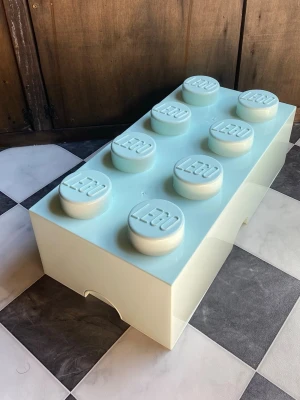 Stor LEGO-förvaringslåda ljusblå - Säljer en stor förvaringslåda från LEGO i form av en klassisk legobit. Lådan är ljusblå, tillverkad i blank plast och har åtta runda knoppar med LEGO-loggan på locket. Perfekt för att förvara småprylar eller leksaker.Små repor överallt annars i utmärkt skick.