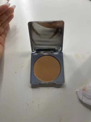 Caia puder - En kompakt puder i en fyrkantig, silverfärgad dosa med stor spegel i locket. Färgen är medium beige med varm underton. Perfekt för att jämna ut hudtonen och ge en naturlig finish. Praktisk att ha med i väskan för snabba touch-ups. Jag har använt den få gånger på grund av den e fel hudton för mig 