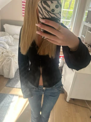 Blå bootcut jeans med låg midja - Säljer ett par klassiska blå bootcut jeans med låg midja och femficksmodell. Jeansen har en snygg tvätt och sitter tajt upptill med utsvängda ben. Perfekta för en trendig och avslappnad look.