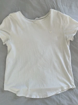 Vit basic t-shirt med liten brodyr - Enkel vit t-shirt i mjuk bomull med rund halsringning och korta ärmar. Liten diskret broderad detalj på bröstet. Perfekt till jeans eller shorts för en clean look. Passar mig som är 14 och har storlek xs men sitter lite tight.
