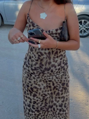 Leopardmönstrad långklänning - Snygg långklänning med leopardmönster och tunna axelband. Klänningen har en avslappnad passform och ett mjukt, följsamt material som ger en trendig look. Använd endast en gång så den är så gott som ny!
