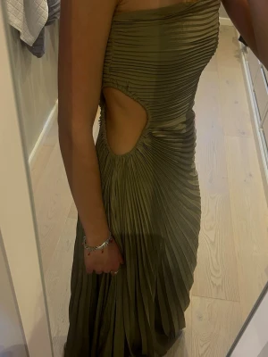 Balklänning med cutout - Militärgrön veckad balklänning, bandeau. Axelbandslös modell. Tyvärr för liten för mig! Jättefin färg och skärning! Perfekt för studentbal eller bröllopsfest. 