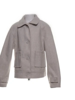 Beige ulljacka med stora fickor - Stilren beige jacka i ull med klassisk krage och stora framfickor. Jackan har knäppning framtill och på ärmsluten, samt en rak och något kortare passform. Perfekt för dig som gillar minimalistisk stil.