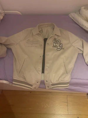 Beige bomberjacka med broderi - Snygg beige bomberjacka med broderade detaljer och text på bröstet. Jackan är från zara 