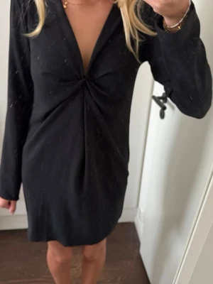 Svart långärmad klänning Zara - Svart kortklänning med lång ärm och snygg twistdetalj framtill vid bysten köpt på Zara. Perfekt sval sommarklänning. Aldrig använt klänningen men klippte av prislappen. Köpt för 400kr, säljer för 90kr. 🌼