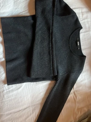 Svart glittrig topp från bikbok  - Snygg svart topp från bikbok med glittrigt tyg och lång ärm. Jätte bra till nyår. Storleken står M men skulle säga  S 