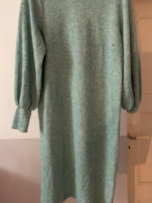 Mintgrön ribbad klänning från Zara - Ribbad mintgrön klänning från Zara med lång ärm och avslappnad passform. Klänningen har en mjuk stickad känsla och ballongärmar med resår vid ärmslut. Perfekt för dig som gillar en enkel men trendig look.