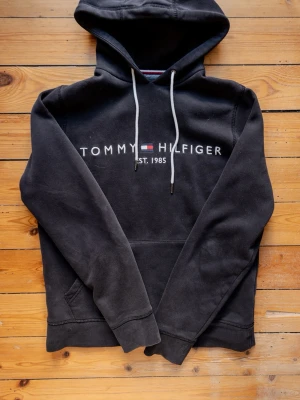 Tommy Hilfiger Hoodie - Säljer en schysst svart hoodie ifrån Tommy Hilfiger i bra skick. Nypris runt 1400kr