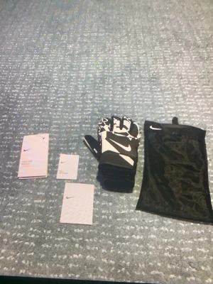 Nike GK Match målvaktshandskar - Säljer ett par svartvita Nike GK Match målvaktshandskar med stor Nike-logga på ovansidan. Handskarna har kardborreband vid handleden och kommer med en svart meshpåse för förvaring. Perfekta för fotbollsträning eller match.