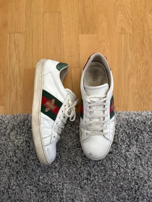 Gucci ace skor herr  - “Extremt snygga och unika Gucci ace perfekt för dig som vill se lite bättre ut en alla de vanliga. De är smutsiga men finns hur mycket kvar som helst och ge,  bra skick inte tvättade ens. Storlek 42!!