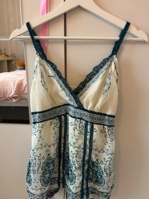 Vitt och blått linne - Jättecoolt och snyggt vitt och blått linne, i ett slags mesh tyg med flera lager, har spets detaljer, justerbara straps och dragkedja. Så många detaljer och coola mönster, har helt enkelt inte varit min stil. OBS! finns en liten lös tråd (i bild 3) men annars inga fläckar