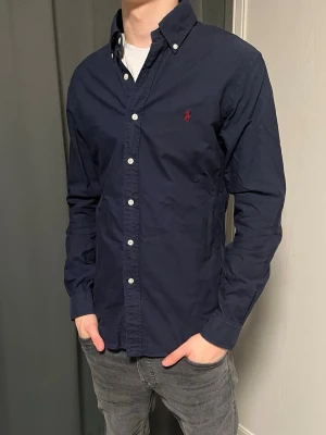 Ralph lauren skjorta mörkblåa - Klassisk marinblå skjorta från Ralph Lauren med rött Ralph lauren märke. Skick 10/10 nypris - 1899kr säljs - 749kr! 