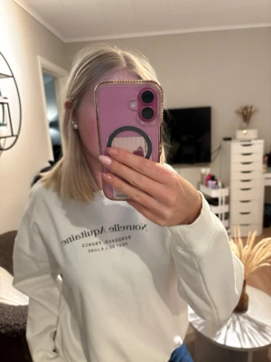 Vit sweatshirt med tryck - Säljer en vit sweatshirt med svart texttryck på bröstet. Tröjan har rund hals och långa ärmar med ribbade muddar. Perfekt för en avslappnad och cool look.