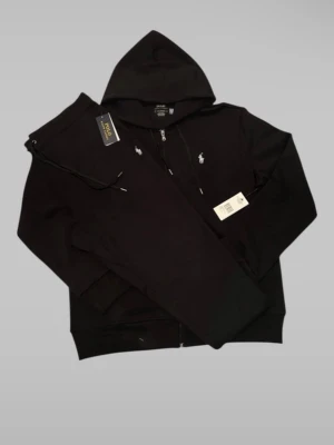 Ralph Lauren Tracksuit Ny Med Tags – Svart – Strl L – Original - Original Ralph Lauren tracksuit i mycket fint skick Ny. Färg: Svart Storlek: L Mått: Byxor – längd ca 105 cm, midja ca 42–52 cm (resår) Zip hoodie – längd ca 70 cm, axelbredd ca 50 cm Endast 1 st. Skickas snabbt. Skriv vid frågor eller seriösa bud. 