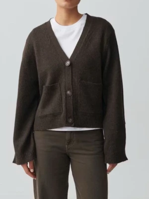 Brun kofta från Gina Tricot - Mysig brun kofta från Gina Tricot med v-ringning, stora framfickor och tre knappar framtill. Koftan har en lite boxig passform och är stickad i ett mjukt material som känns fluffigt. Perfekt att slänga över en t-shirt eller topp.