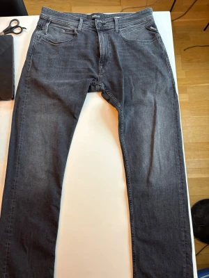 Grå slim fit jeans från Replay - Snygga grå jeans från Replay i slim fit-modell. Klassisk femficksdesign med svarta detaljer och diskret Replay-logga på bakfickan. Jeansen har en modern tvätt och är tillverkade i mjukt denimtyg som sitter skönt hela dagen.