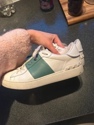 Valentino Open sneakers vit/grön 38,5 - Snygga Valentino Open sneakers i storlek 38 1/2 de är supersnygga och såklart äkta!! Hör av er vid frågor. Innesulan är 25 cm💕💕