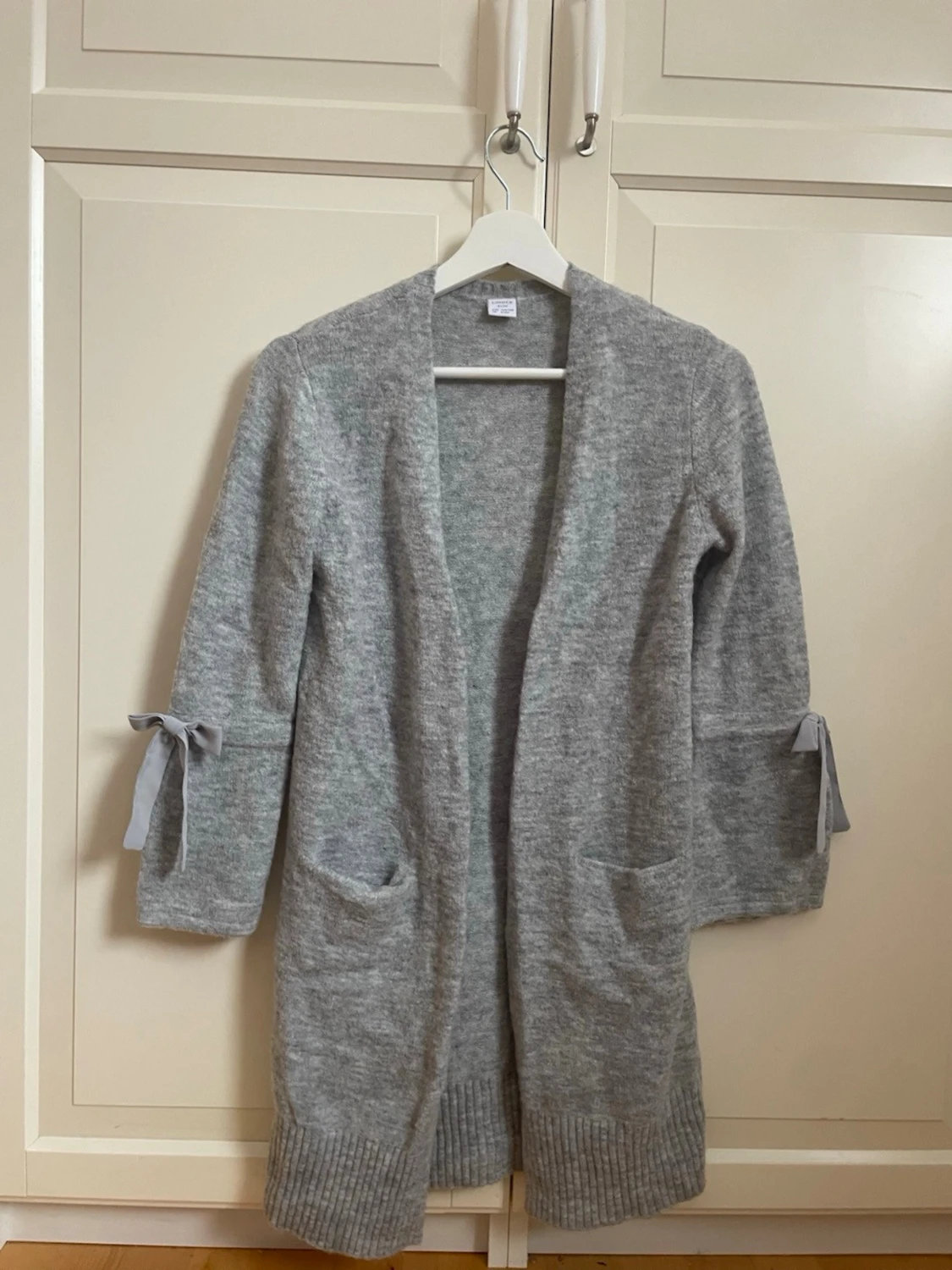 Ljusgrå lång kofta med rosetter