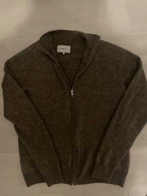 Brun ziptröja från Norvie - Mysig brun ziptröja från Norvie i storlek L. Tröjan har hel dragkedja framtill, ribbade muddar och en enkel, stilren design. Perfekt för lager-på-lager och chill dagar. Materialet känns riktigt mjukt vilket är perfekt ifall du gillar varma kläder